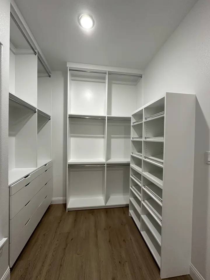 Walk-in closet with hanging rods, drawers and a tall shoe shelf unit