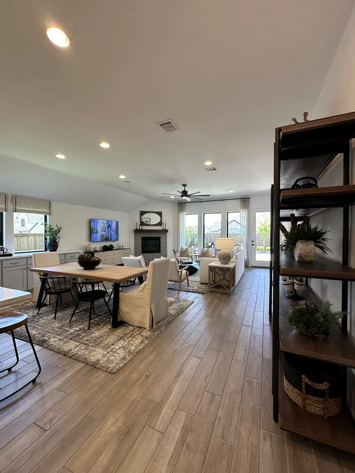 Open dining and living area with continuous wood-look plank flooring